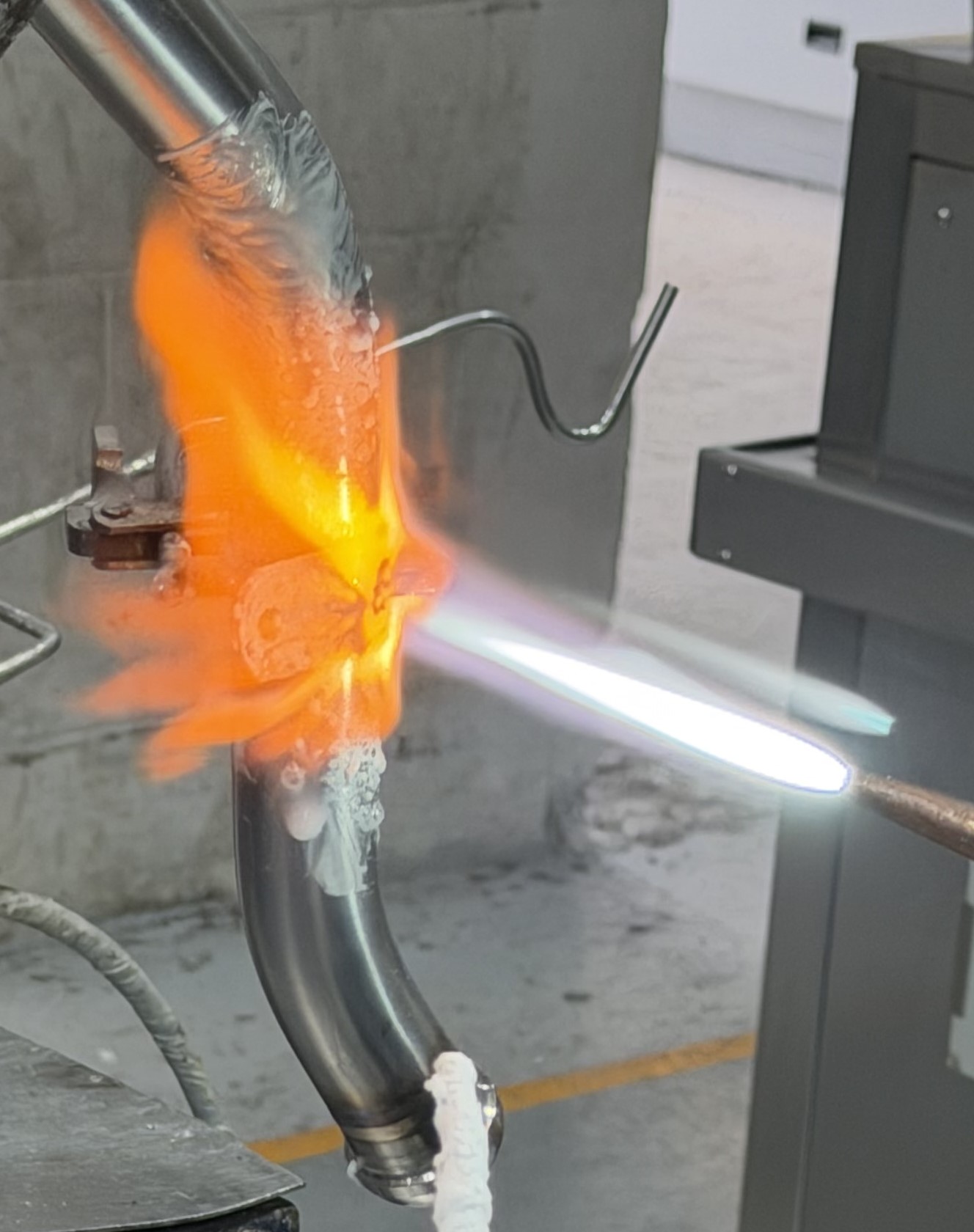 Torch brazing of an aircraft pipe system component. An acetylene flame is used to heat the flux-coated assembly.