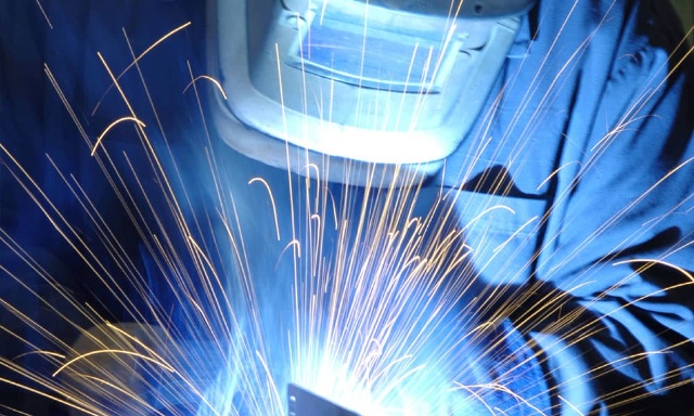 person in ppe welding