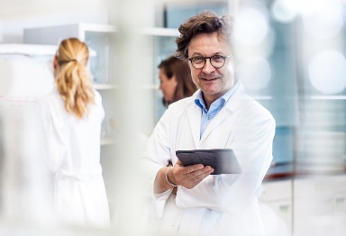 doctor with tablet standing in a facility manufacturing medical devices