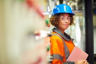 female health and safety professional wearing a blue hat and orange vest